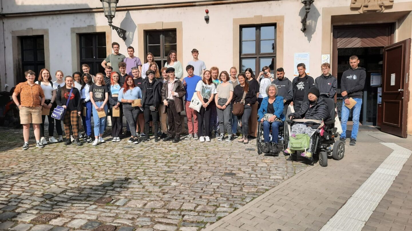 Gruppe von Menschen mit und ohne Rollstuhl